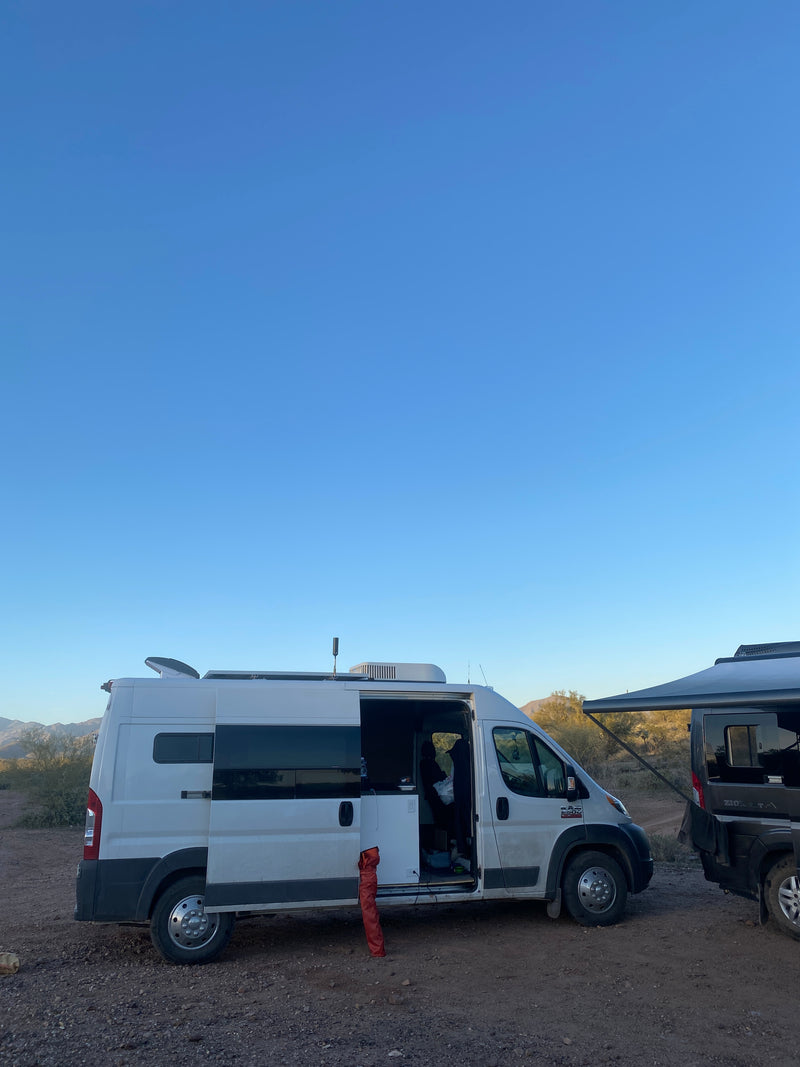 White RV rental with side door open, parked next to another van in a sunny desert campsite. Ideal for your next outdoor adventure. — photo 15