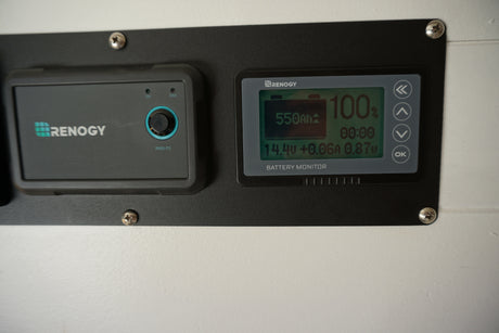 Renogy battery monitor and RMS-P2 controller in an RV rental, showing 100% charge and 550Ah capacity.