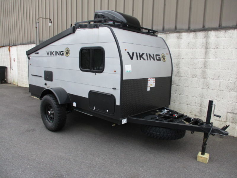 Ready for your next rv rental adventure: a gray and black compact Viking travel trailer with off-road tires and roof rack.