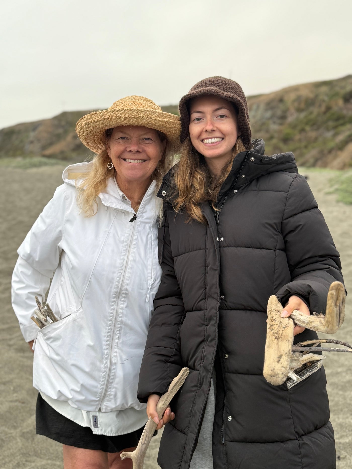 Smiling women with collected driftwood on a beach, enjoying their RV rental vacation. — photo 19