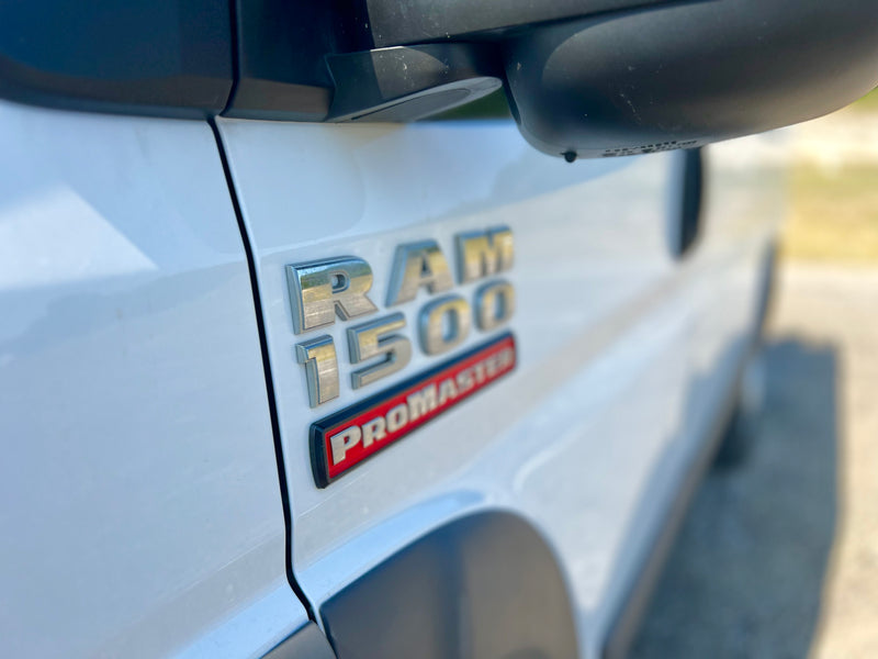 Close-up of a white Ram ProMaster 1500 van's side, showing metallic 'RAM 1500' and red 'ProMaster' badges. Ideal for rv rental. — photo 17