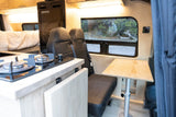 Explore this RV rental's spacious camper van interior with a kitchen, comfy bed, seating, and scenic views.