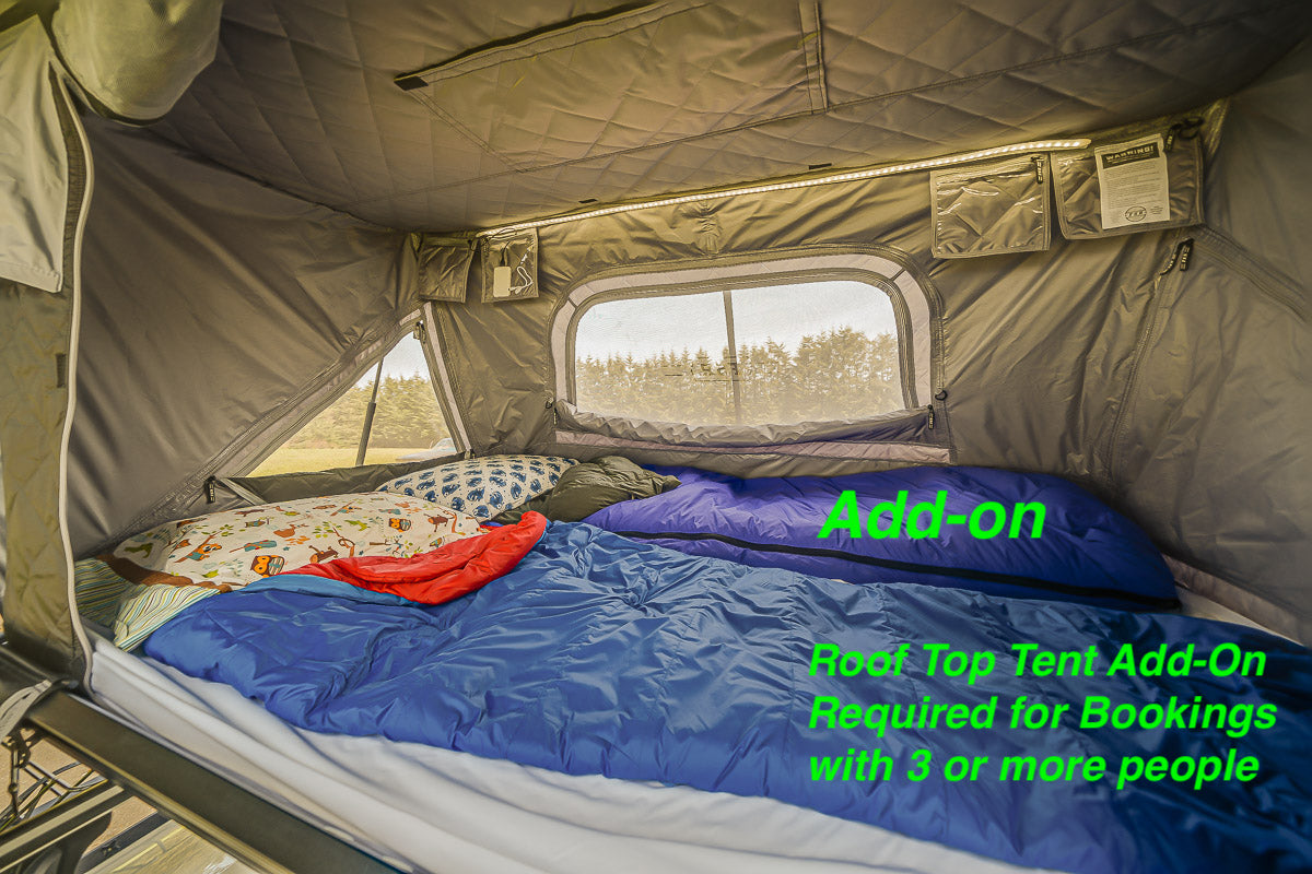 Rooftop tent add-on for RV rentals: a spacious sleeping area with bedding, windows, and internal lighting.