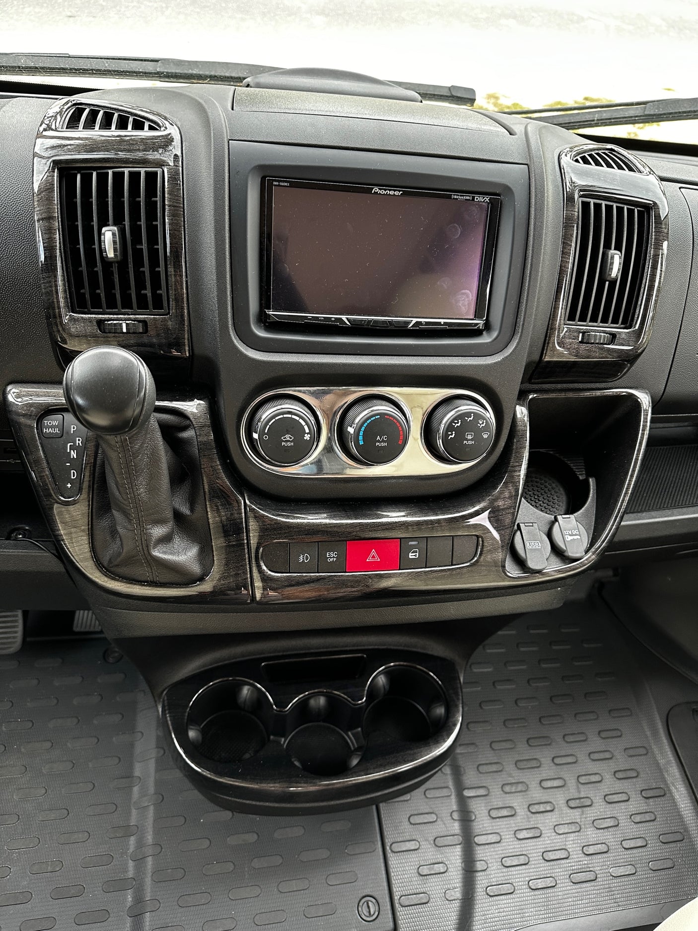 RV rental control panel: detailed view of vehicle interior with dashboard, Pioneer screen, climate controls, shifter, and charging ports.