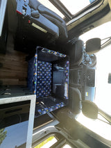 Inside an RV rental, a child's playpen with an elephant pattern is central, flanked by a kitchen and front cockpit.