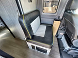 Explore this RV rental interior, featuring a two-tone bench seat with yellow trim, wood flooring, and a side window.
