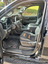 Detailed interior of a GMC truck, showing the driver's seat with orange accents, steering wheel, and dashboard. Great for an rv rental.
