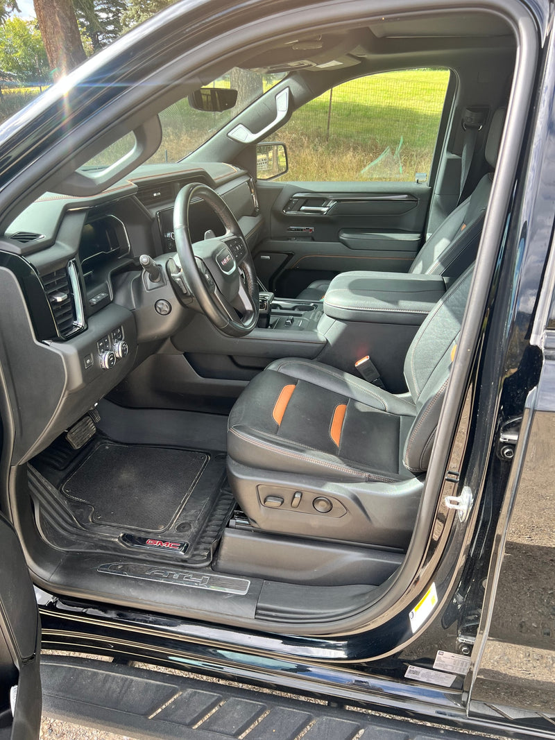 Detailed interior of a GMC truck, showing the driver's seat with orange accents, steering wheel, and dashboard. Great for an rv rental. — photo 7