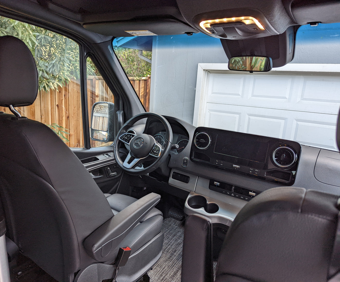 Step inside this rv rental, featuring a spacious cockpit with a Mercedes-Benz steering wheel, dashboard, and comfy driver's seat.