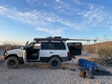 Overlanding SUV with awning set up in the desert for camping, a great alternative to an RV rental for off-grid trips.