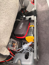 S ZEVZO power pack, compressor, fuse box, & car accessories in organized RV rental storage for essential vehicle power.