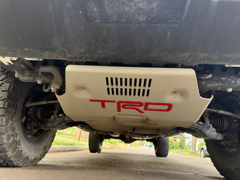 Underside view of a rugged vehicle with TRD skid plate and off-road tires. Perfect for adventure, consider an RV rental! — photo 13