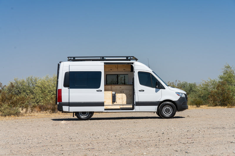  and ample storage.|Spacious RV rental interior featuring a custom wooden build with kitchenette — photo 3
