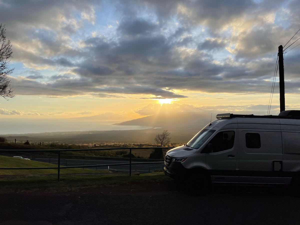  overlooking ocean waves. Ideal for coastal adventures.|An RV rental camper van silhouetted against a golden sunset over the ocean. Scenic overlook.|Nighttime view of an RV rental parked on a hill — photo 2