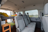 Inside a comfy RV rental: a built-in bed and multiple passenger seats, perfect for mobile adventures.