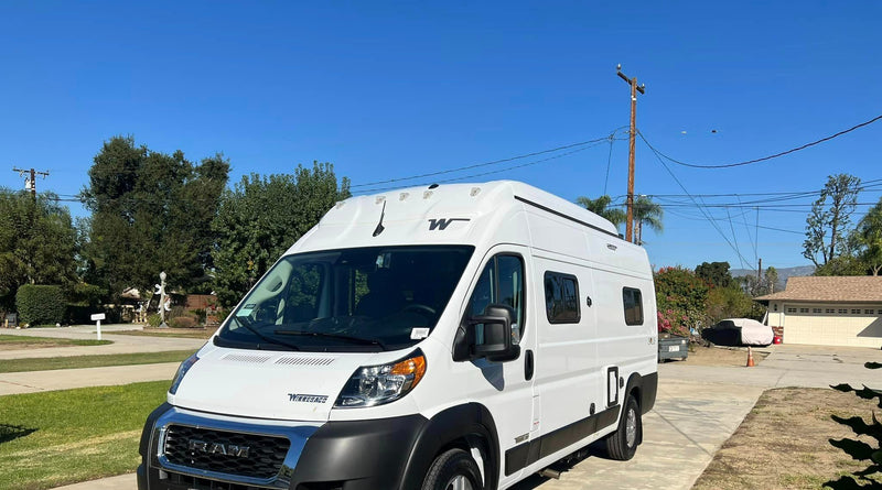  parked outdoors on a sunny day.|White Winnebago Solis rv rental with extended pop-top and open side/rear doors — photo 3