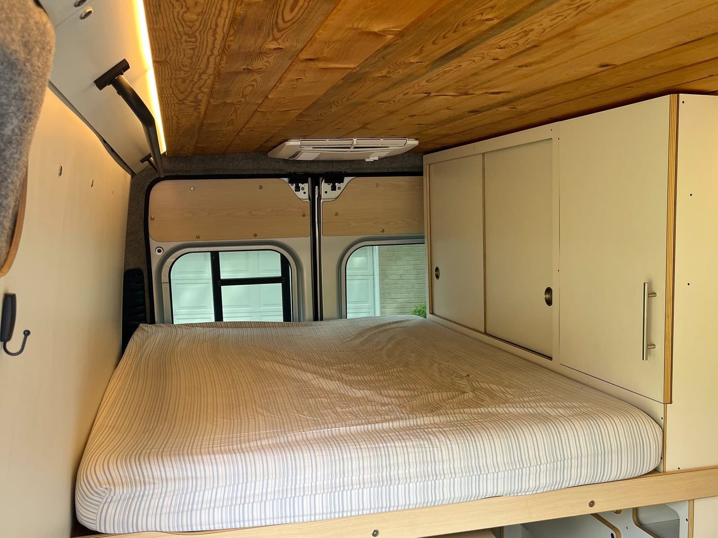  and beautiful wooden ceiling.|Modern RV rental kitchen with integrated induction cooktop — photo 16