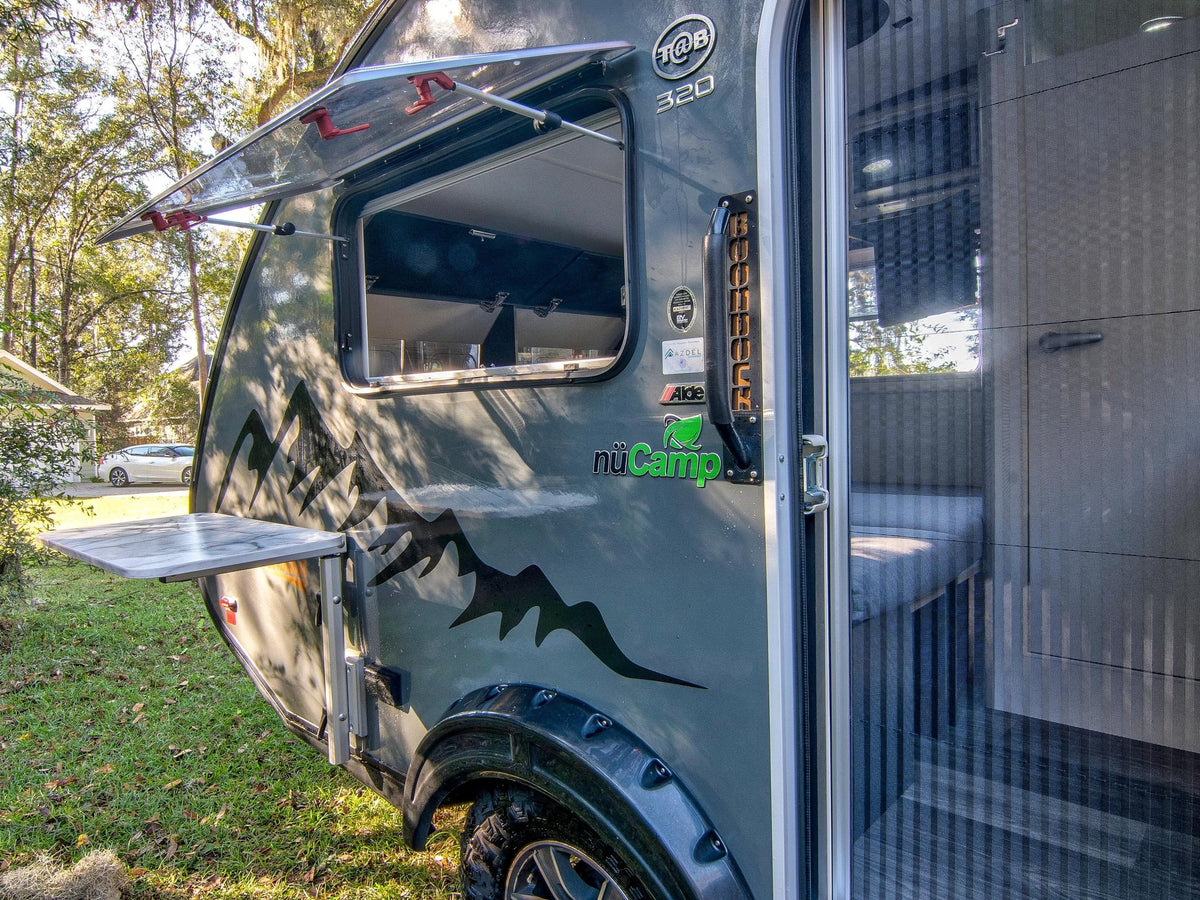  a compact travel trailer with mountain graphics and open door for outdoor adventures.|A modern grey teardrop RV rental — photo 2