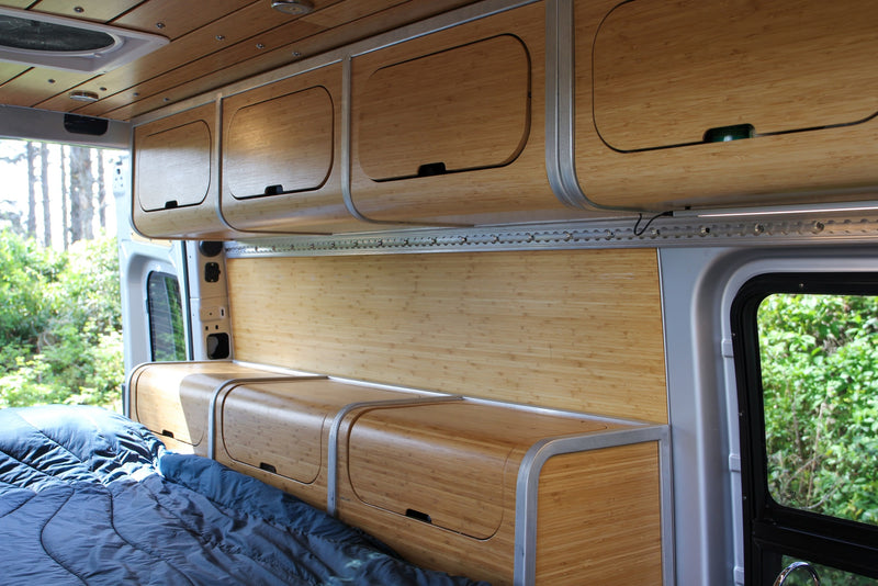 An RV rental interior with sleek bamboo cabinets, bed, and wall panels, offering a cozy mobile living space. — photo 6