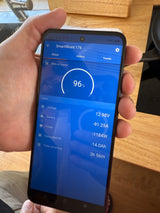 Real-time RV rental battery monitoring via SmartShunt app: 96% charged, 12.98V, 3h 56m remaining on phone screen.