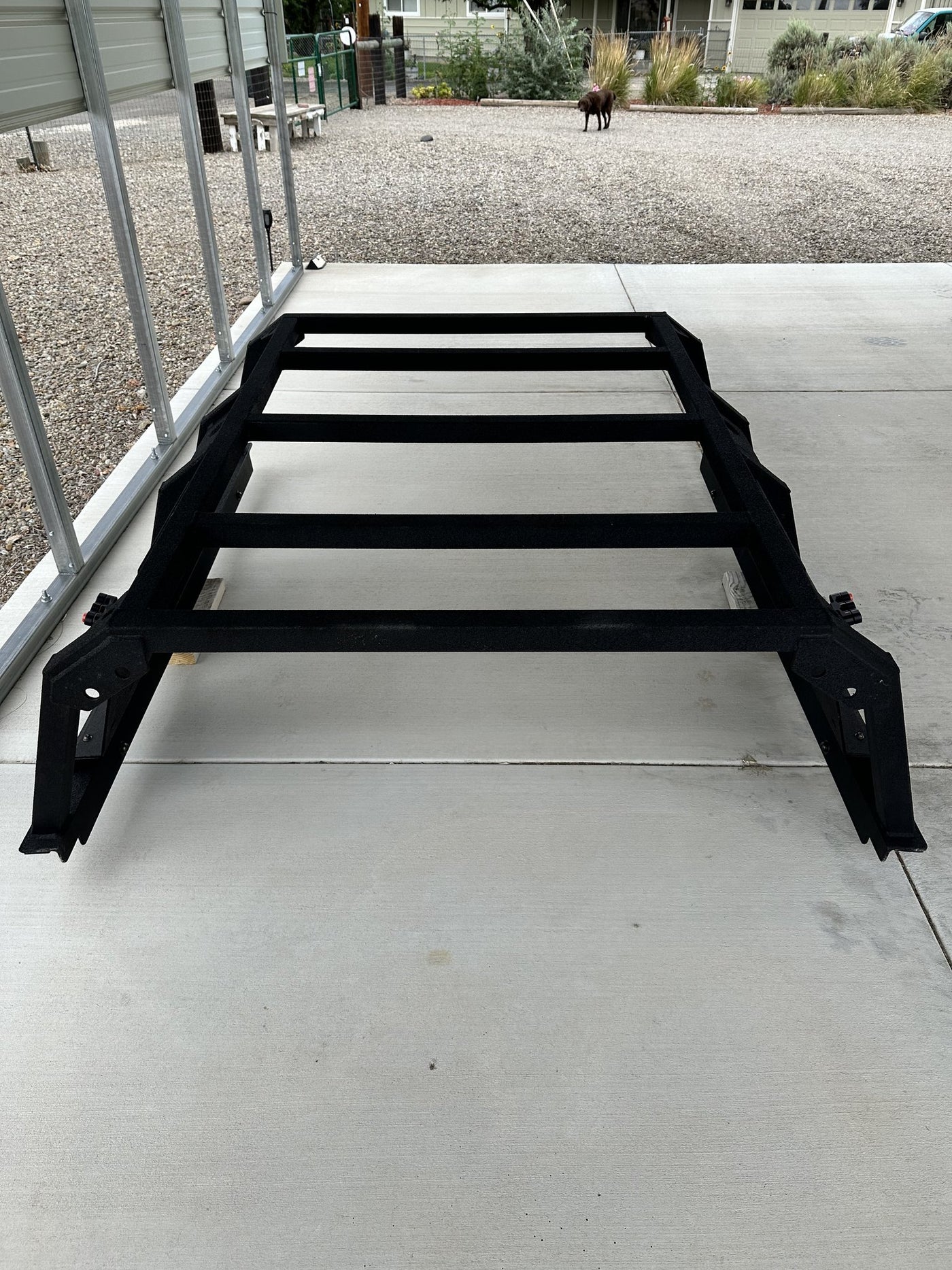 Full-length view of the bed rack from the tailgate end showing all five 2 inch square tube crossbars, the quarter inch L angle running the length of the bed and the four bed mounting feet — photo 2