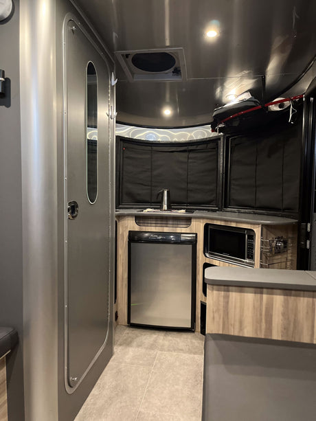 Step inside this modern RV rental! Featuring a sleek kitchen with fridge, microwave, and ample counter space for your travels.