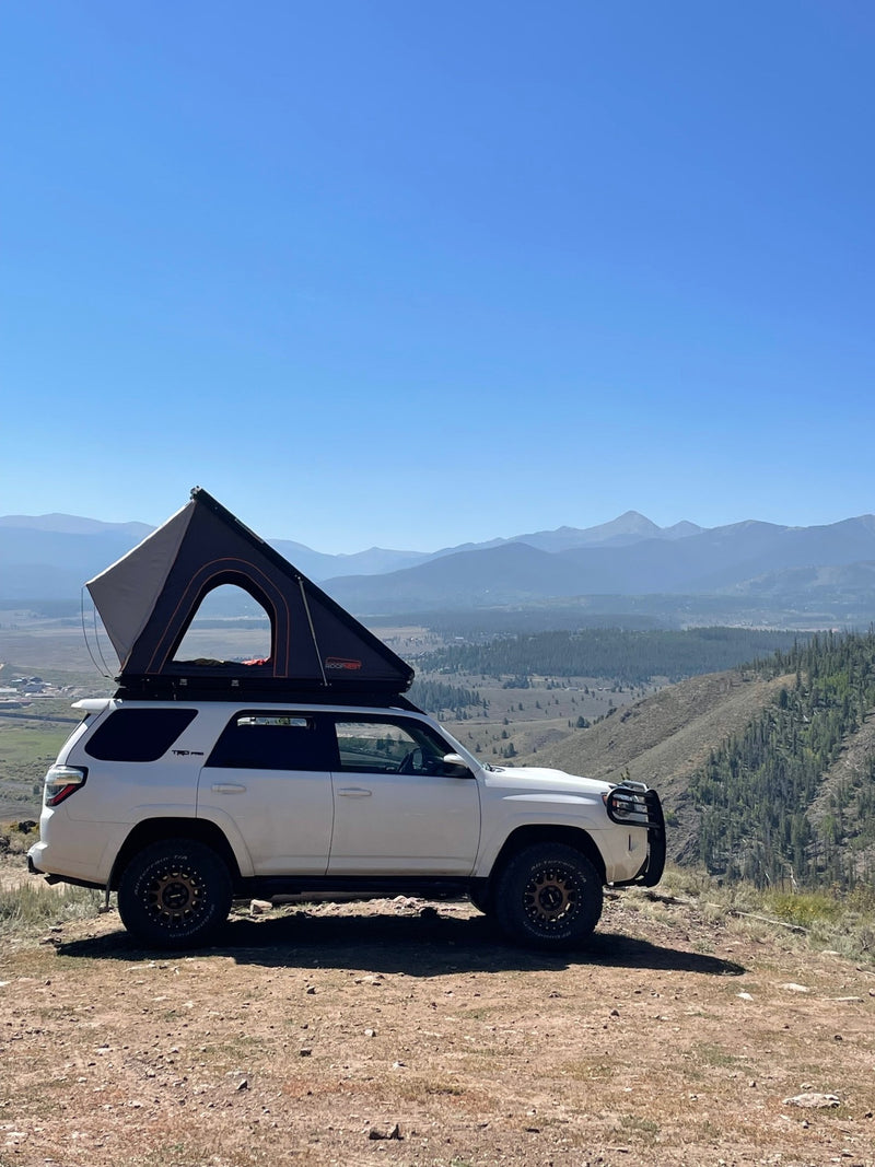 Experience mountain camping! White 4Runner with a rooftop tent deployed, ideal for an RV rental journey overlooking a valley. — photo 12