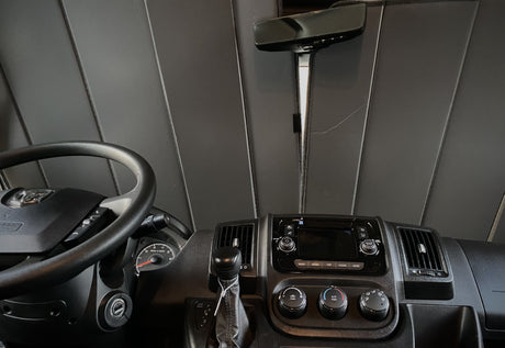 Inside an RV rental: driver's view of the dashboard, steering wheel, media console, and climate controls.