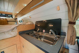 RV rental: Enjoy a compact kitchen with two-burner stove, sink, and a comfortable bed in this well-designed campervan.