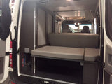 Explore this RV rental's comfortable and modular camper van interior. Features include a convertible bed & storage.