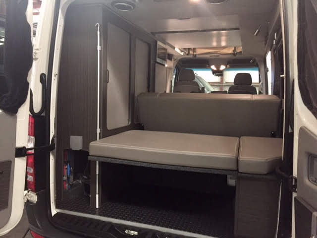  ready for off-grid mountain adventures.|Explore our RV rental's versatile interior: a well-equipped camper kitchen with microwave — photo 5