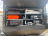 Organized gear inside an RV rental's rear storage. Cases for toiletries, kitchen, and dry food streamline adventures.