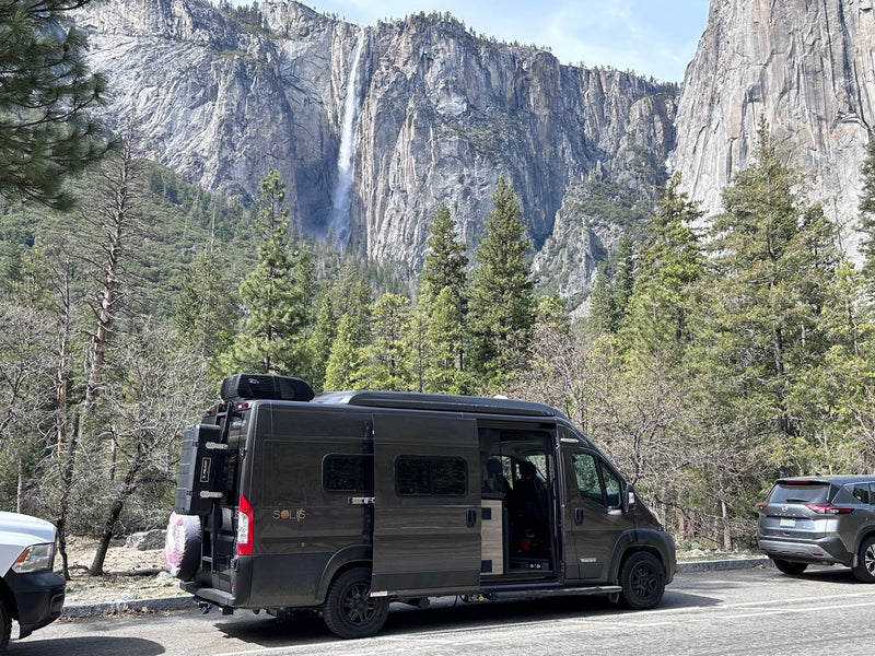 An rv rental, a Winnebago Solis camper van, parked in front of towering Yosemite Falls and granite cliffs. Perfect nature travel. — photo 8