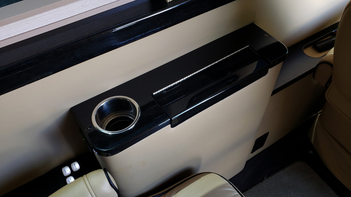 Inside an RV rental: a plush interior featuring a built-in console with cup holder and lighting controls for passenger comfort.