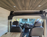 Custom RV rental camper van interior featuring wooden plank ceiling, white paneled walls, and the front driver's area.