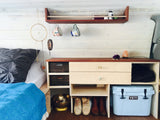 This RV rental features a cozy bed, custom storage with a Yeti cooler, and ambient lighting for your journey.