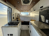 RV rental with a full kitchen, cozy bed, and stunning beach views. Ideal for a coastal adventure.