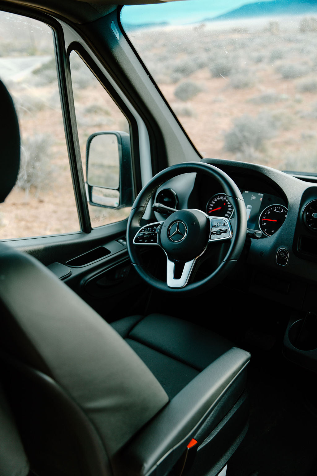 Step into this comfortable RV rental. The spacious interior features a modern Mercedes dashboard and steering wheel, perfect for desert road trips.