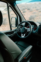 Step into this comfortable RV rental. The spacious interior features a modern Mercedes dashboard and steering wheel, perfect for desert road trips.
