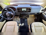 Spacious Mercedes Sprinter RV rental interior: driver's view of dashboard, steering wheel, and cream leather seats.