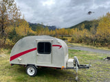 Explore misty autumn mountains with this silver teardrop camper. An ideal rv rental for a cozy fall getaway amidst golden trees.