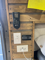 RV rental van's interior wall with MaxxAir fan remote, light dimmer, Renogy power switch, and USB outlet.