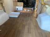 RV rental build: Interior with new wood flooring, shower pan, and custom-built features underway.