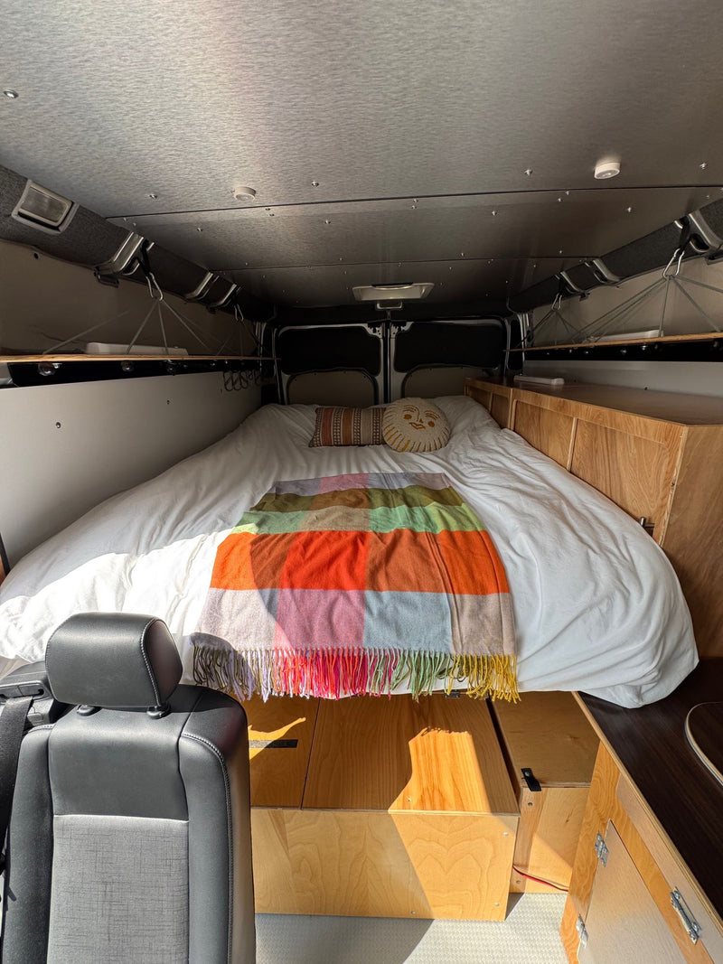  a spacious option for rv rental.|Cozy RV rental interior: A spacious bed with a vibrant blanket — photo 2
