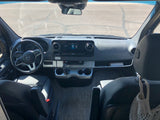 View from driver's seat of an RV rental: Mercedes-Benz dashboard, steering wheel, and display. Sunny road ahead, ready for adventure!