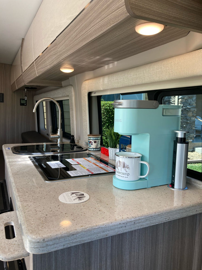 Bright RV rental kitchen featuring a teal Keurig, induction cooktop, and sink. Perfect for on-the-go meals. — photo 12