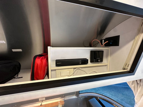 RV rental interior: overhead storage with Sony media player, JL Audio stereo, and a red first aid kit.