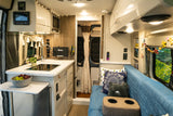 Cozy rv rental interior with a functional kitchenette, comfy seating, and scenic window views of yellow flowers, ideal for travel.