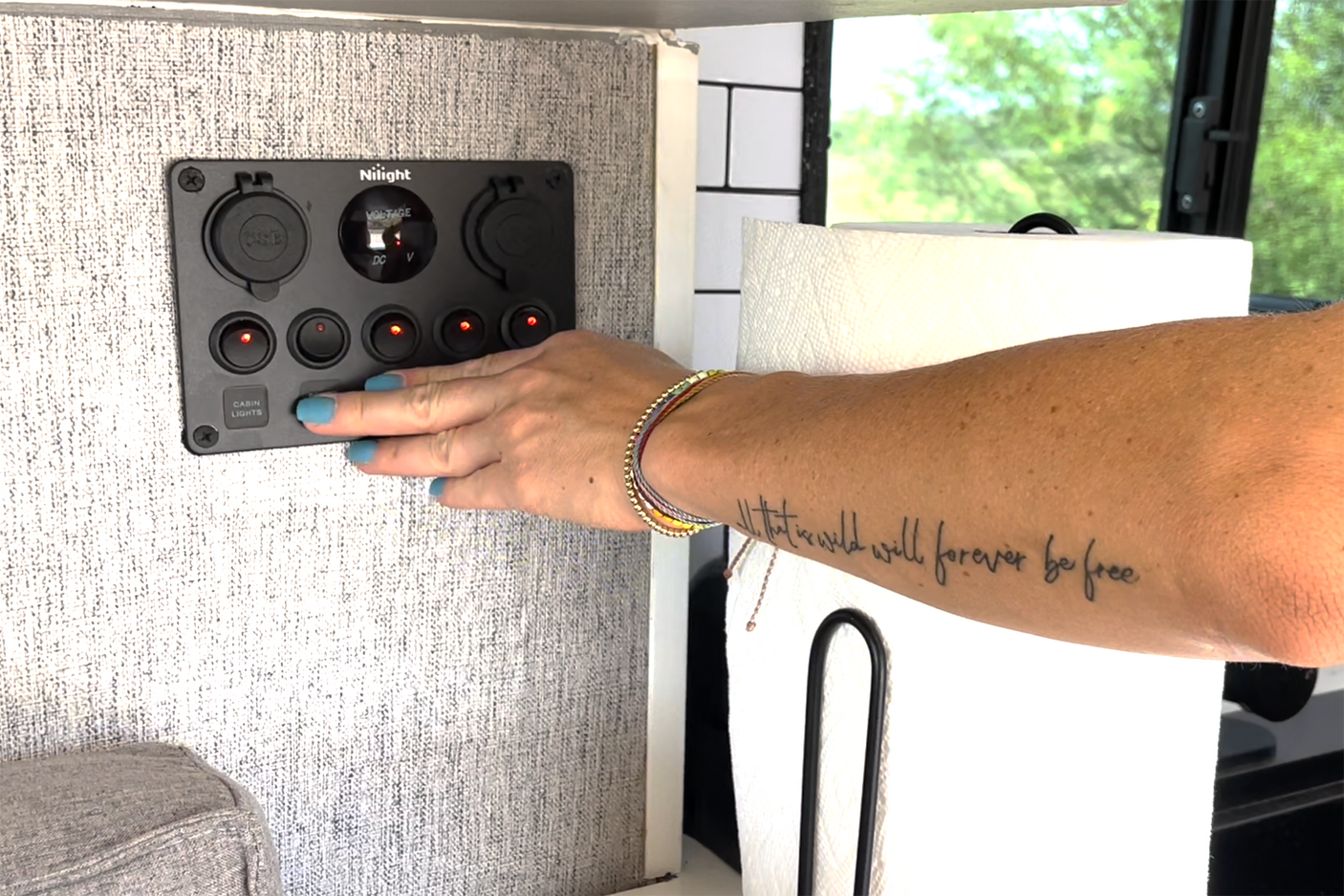 Activating cabin lights on an RV rental's Nilight control panel, showing a voltage meter. Essential for comfortable travel.