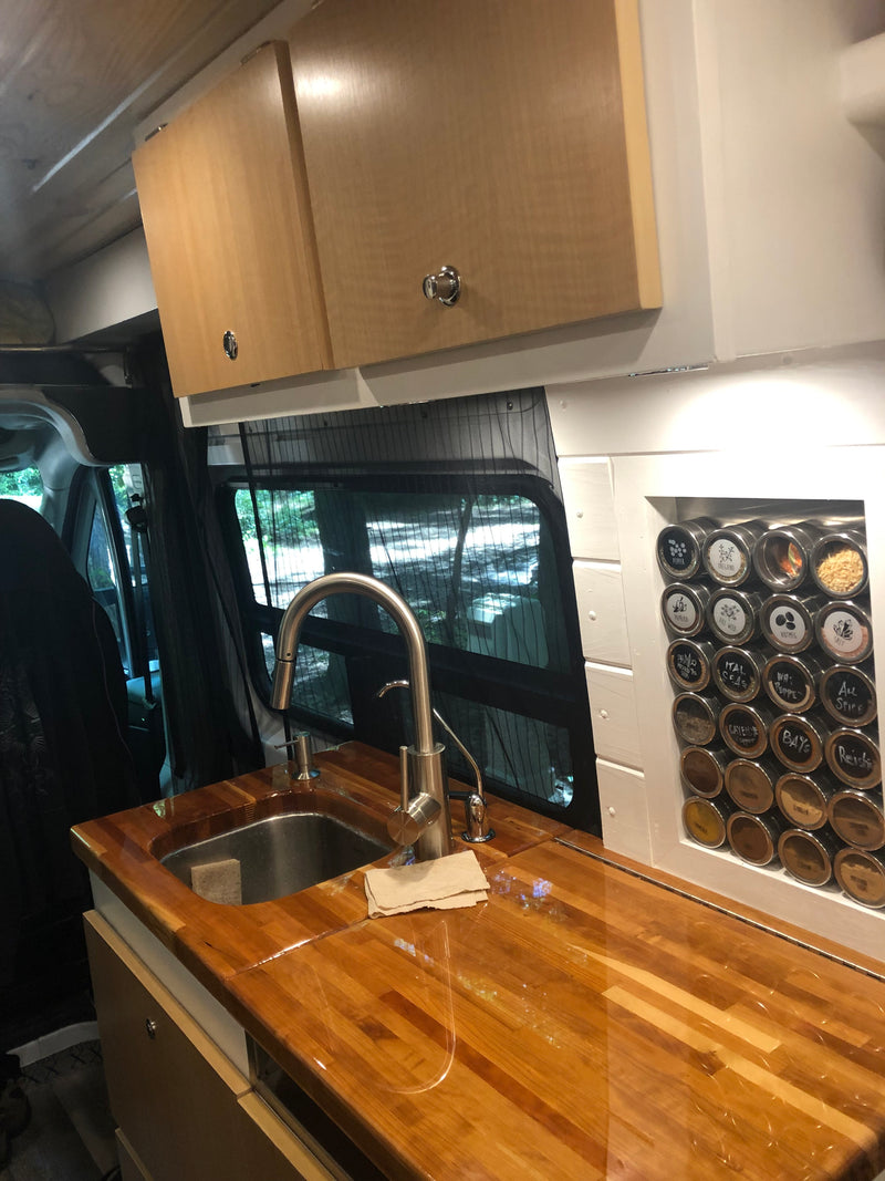 This RV rental's kitchen boasts a sleek wood countertop, sink, and a clever magnetic spice rack, ideal for on-the-go cooking. — photo 3